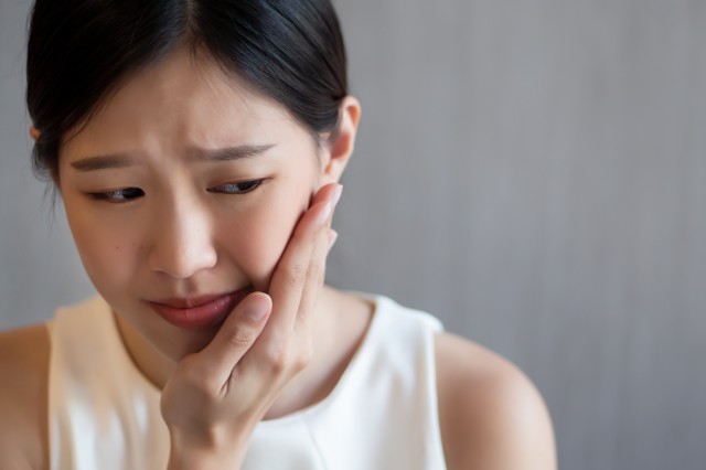 歯の痛みを感じる女性