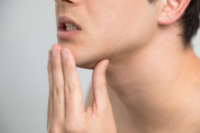 歯の痛みを感じる男性