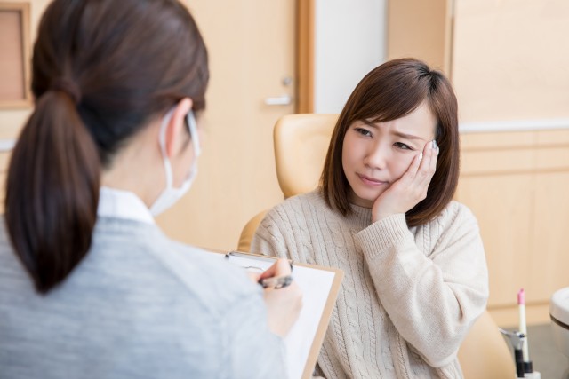 歯の痛みについて相談する女性